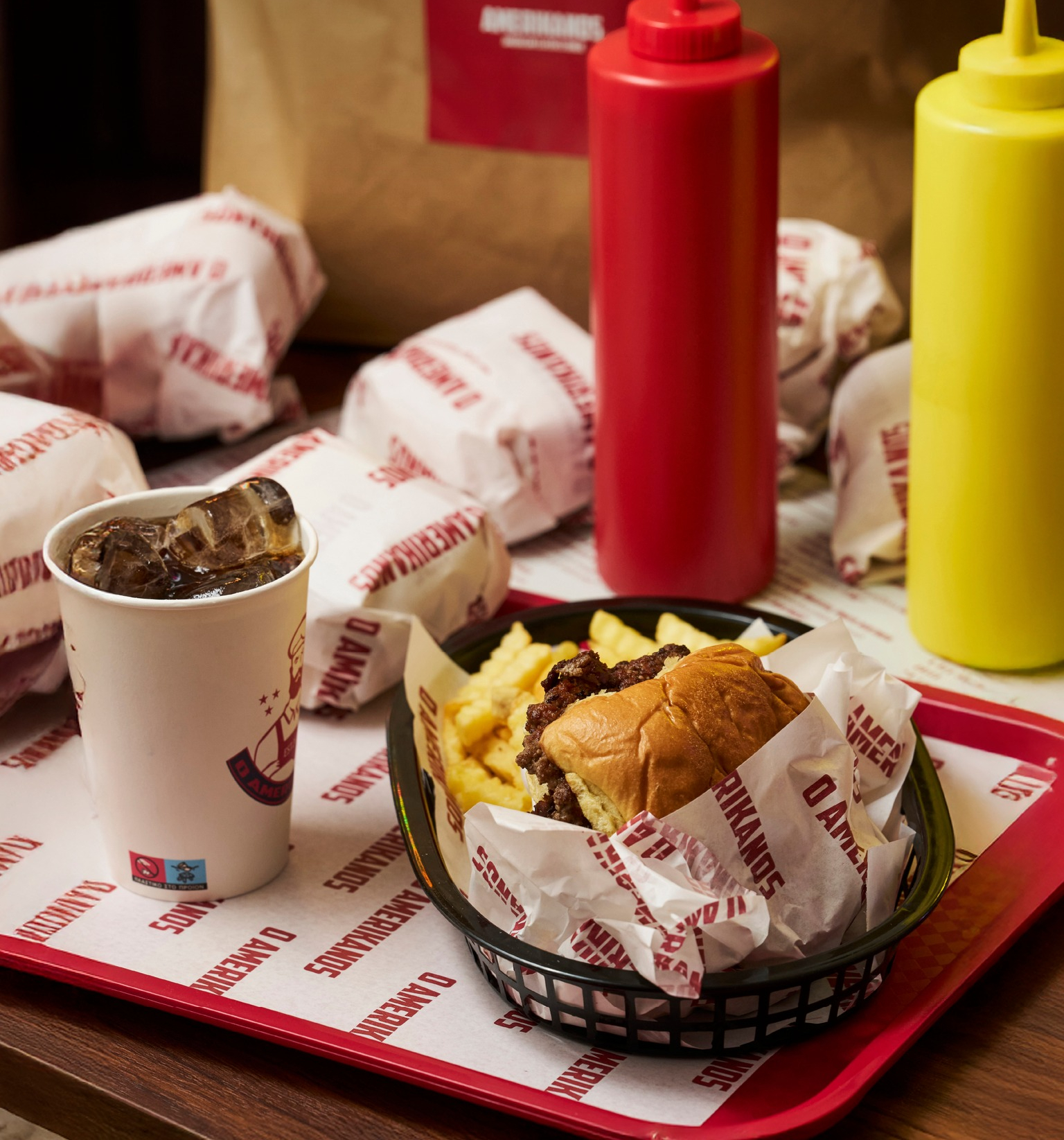 AMERIKANOS kitchen — staff preparing smash burgers on the flat-top grill